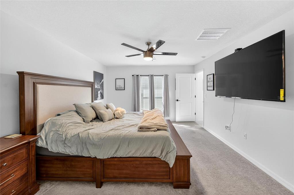 13073 Garnet Raspberry Avenue Wimauma, FL 33598 - Photo 39 of 50 a bedroom with bed tv and a large window