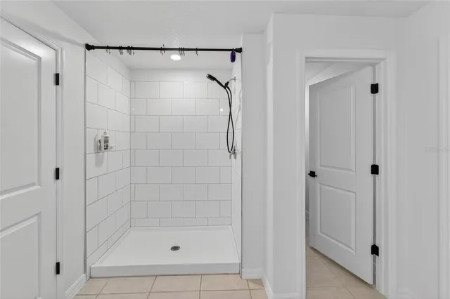 a spacious bathroom with a granite countertop sink a mirror and a bathtub