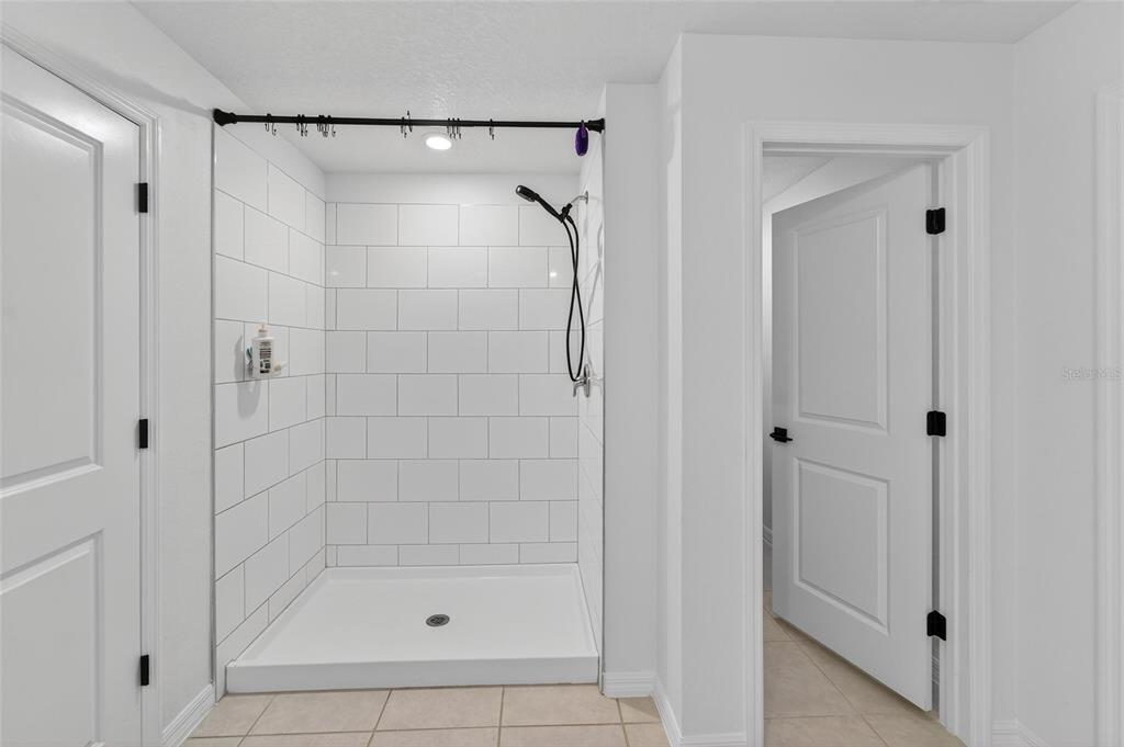 13073 Garnet Raspberry Avenue Wimauma, FL 33598 - Photo 41 of 50 a bathroom with a glass shower door