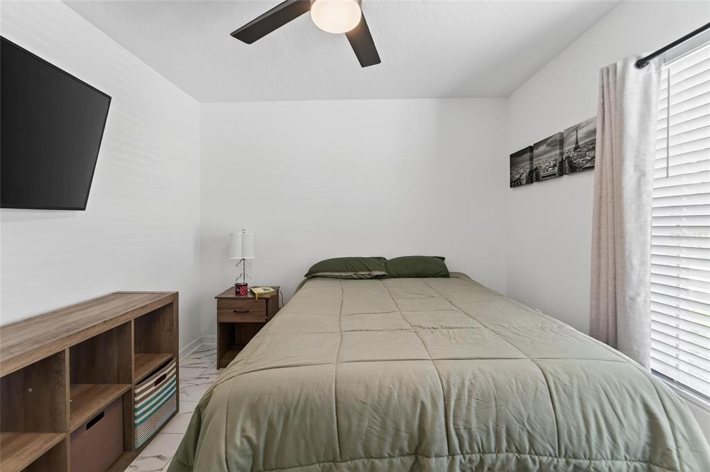 13073 Garnet Raspberry Avenue Wimauma, FL 33598 - Photo 9 of 50 a bedroom with a bed and a flat screen tv