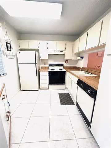 a kitchen with stainless steel appliances a stove a sink and a refrigerator