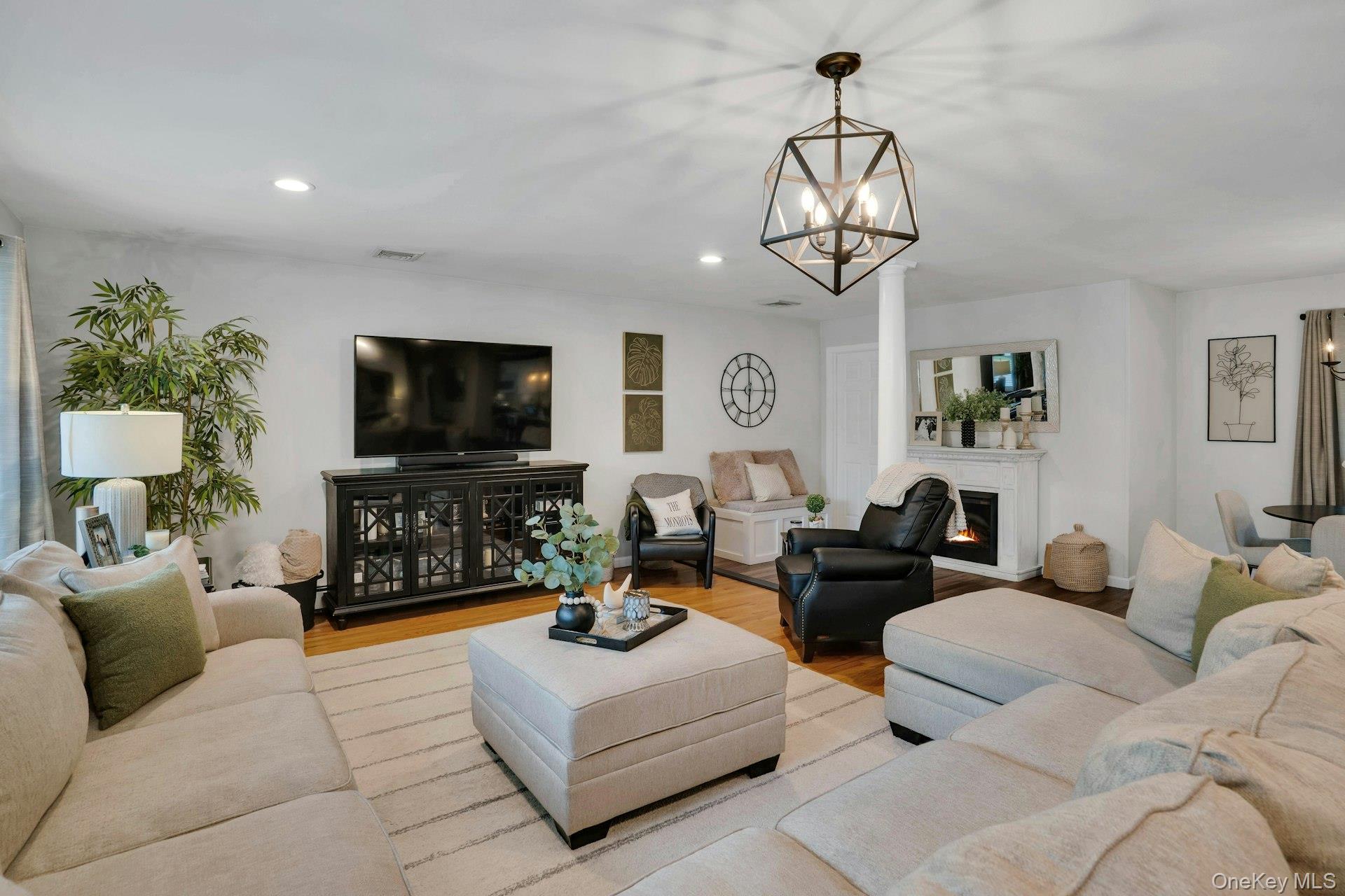 12 Rachel Avenue Commack, NY 11725 - Photo 16 of 50 a living room with furniture a chandelier and a flat screen tv