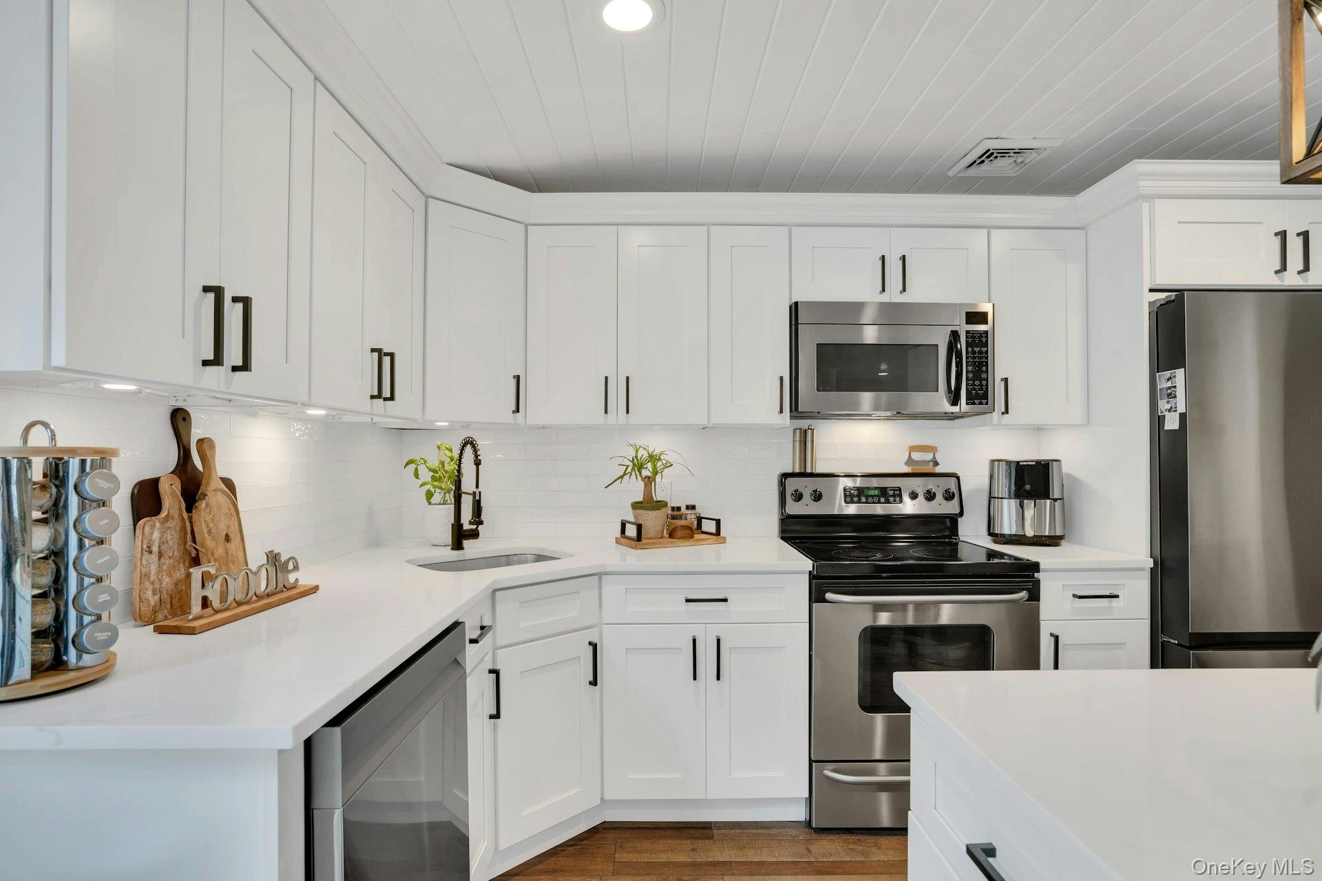 12 Rachel Avenue Commack, NY 11725 - Photo 22 of 50 a kitchen with cabinets stainless steel appliances and wooden cabinets