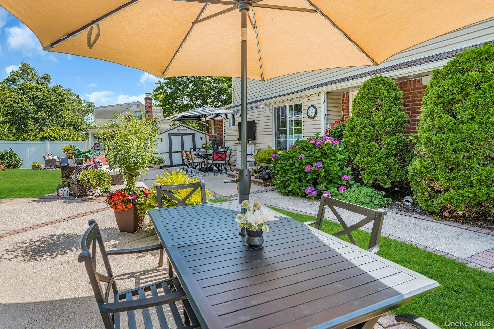 12 Rachel Avenue Commack, NY 11725 - Photo 40 of 50 a view of a patio with couches table and chairs under an umbrella