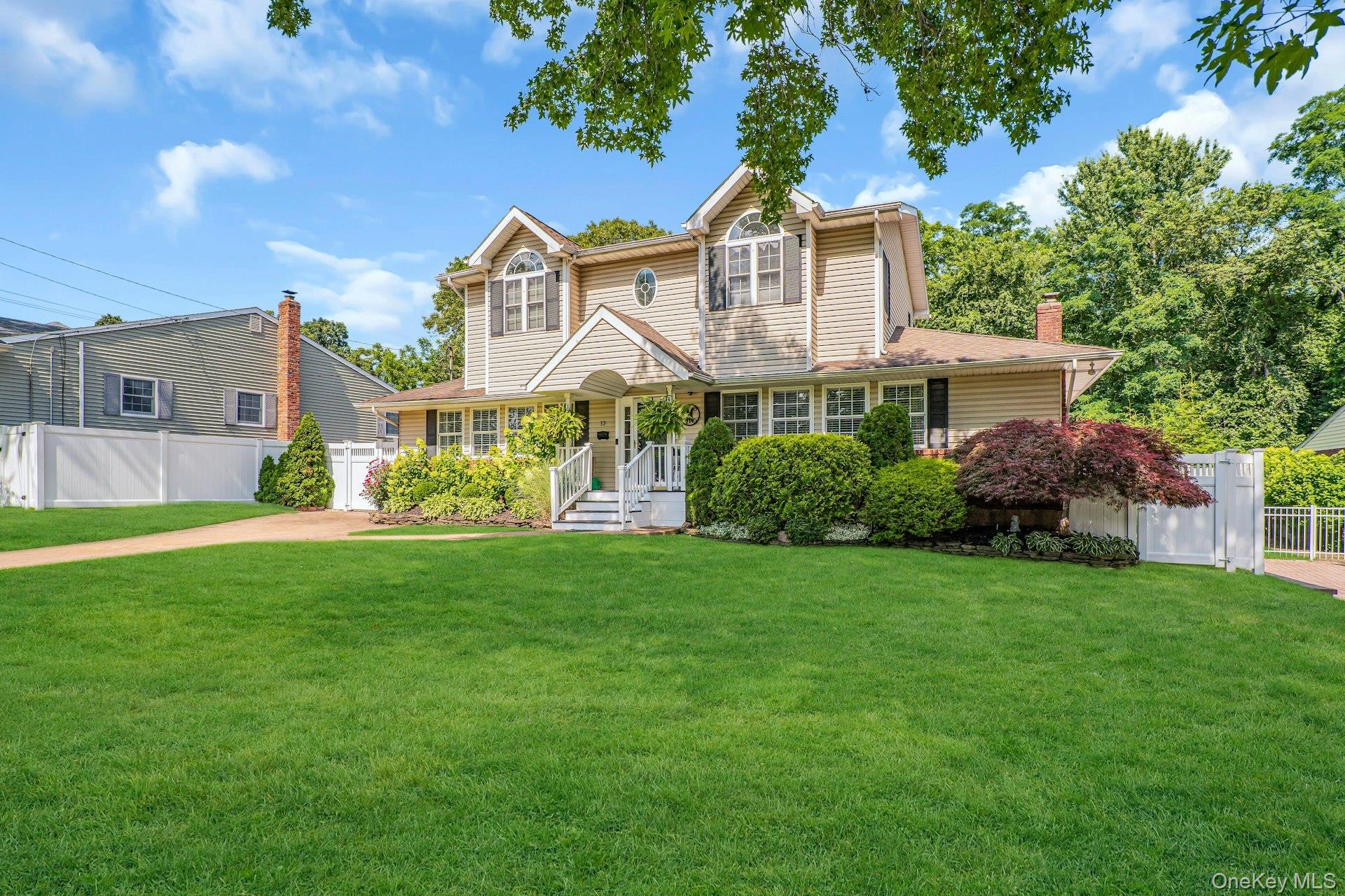 12 Rachel Avenue Commack, NY 11725 - Photo 4 of 50 a front view of a house with a yard and trees