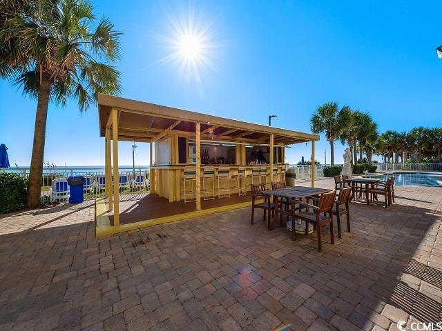 2000 North Ocean Boulevard, Unit 1612 Myrtle Beach, SC 29577 - Photo 16 of 21 View of patio featuring a bar, a community pool, and a water view