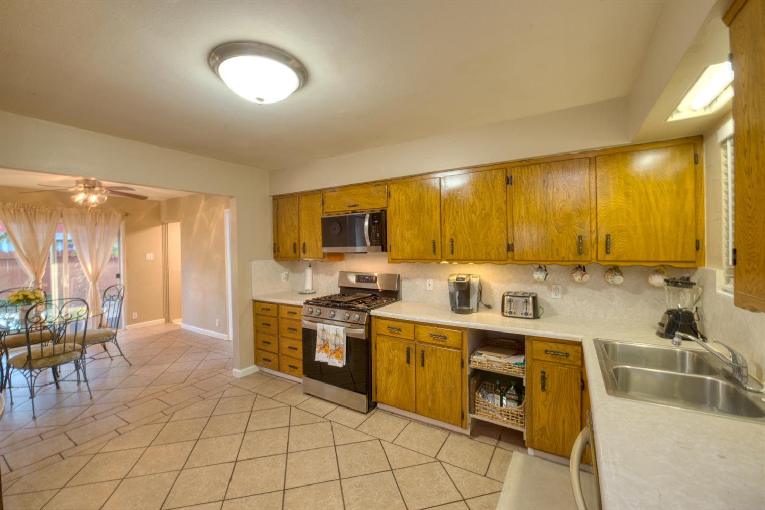 902 Waller Street Gustine, CA 95322 - Photo 12 of 32 a kitchen with a sink dining table and chairs