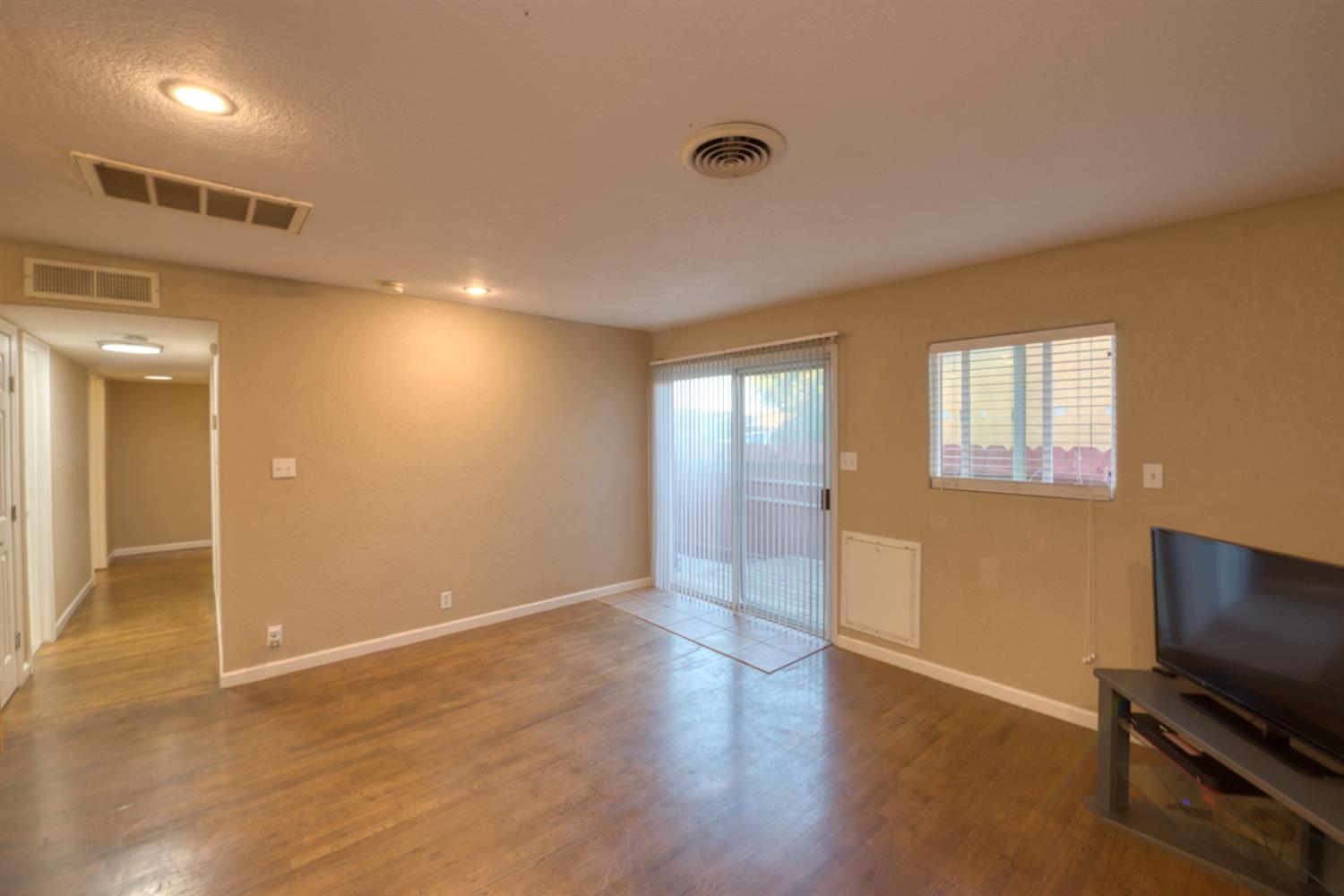 902 Waller Street Gustine, CA 95322 - Photo 16 of 32 a view of an empty room with wooden floor and a window