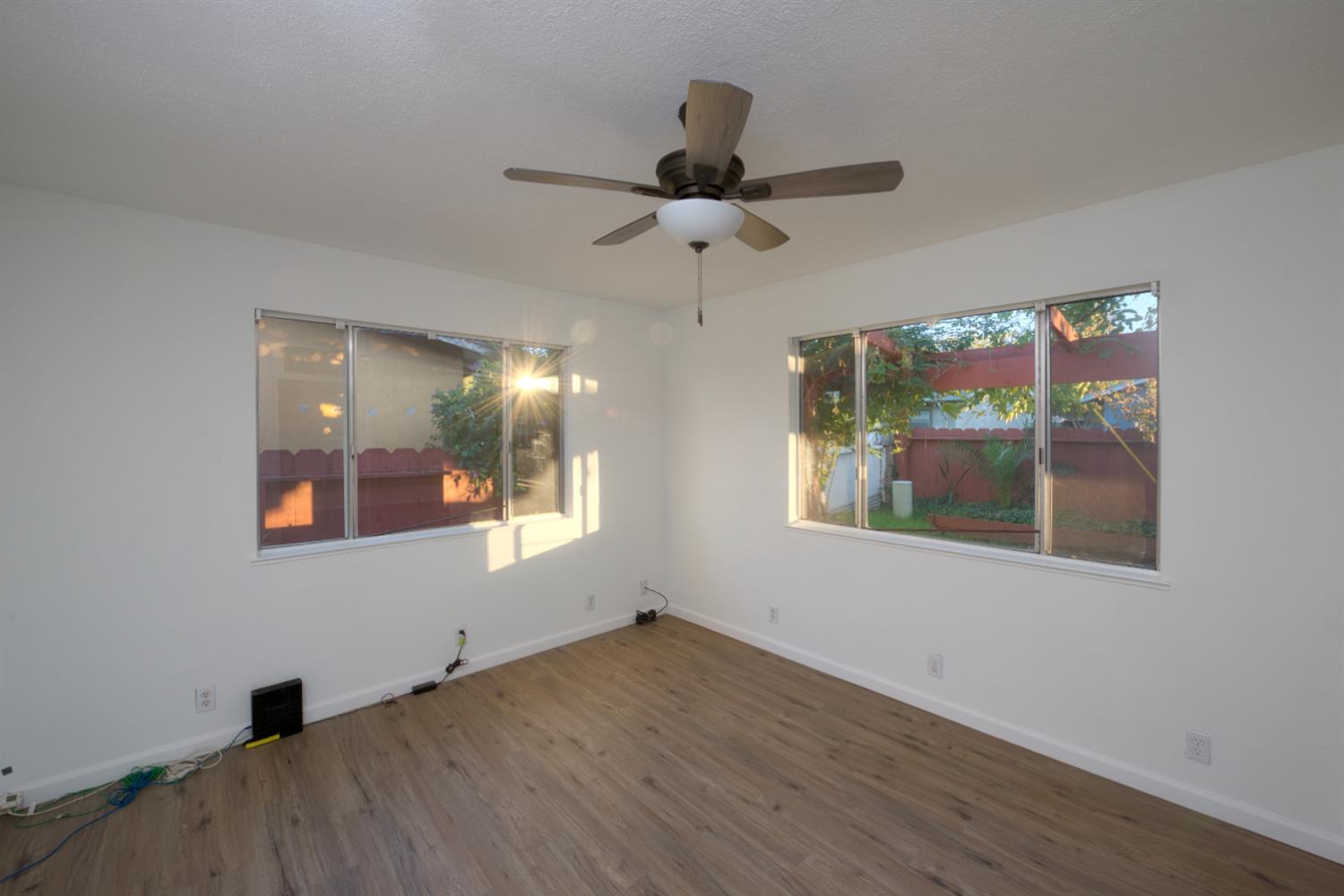 902 Waller Street Gustine, CA 95322 - Photo 19 of 32 an empty room with wooden floor fan and windows