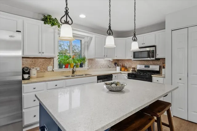 a kitchen with a sink a stove and chairs
