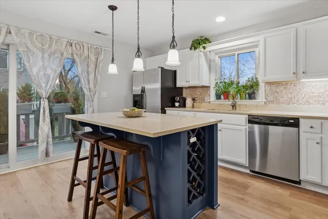 a kitchen with a table chairs sink and cabinets