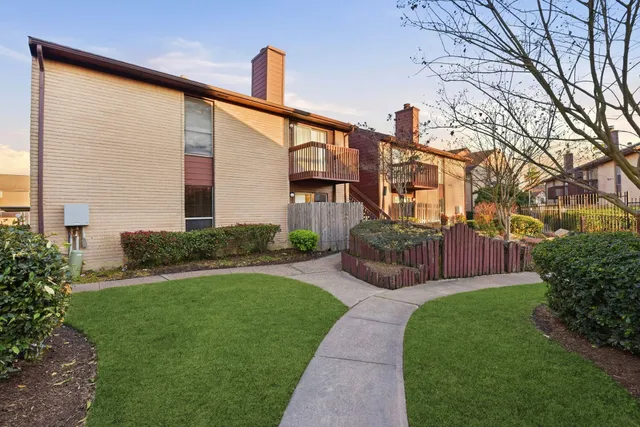 a view of a house with backyard and a tree