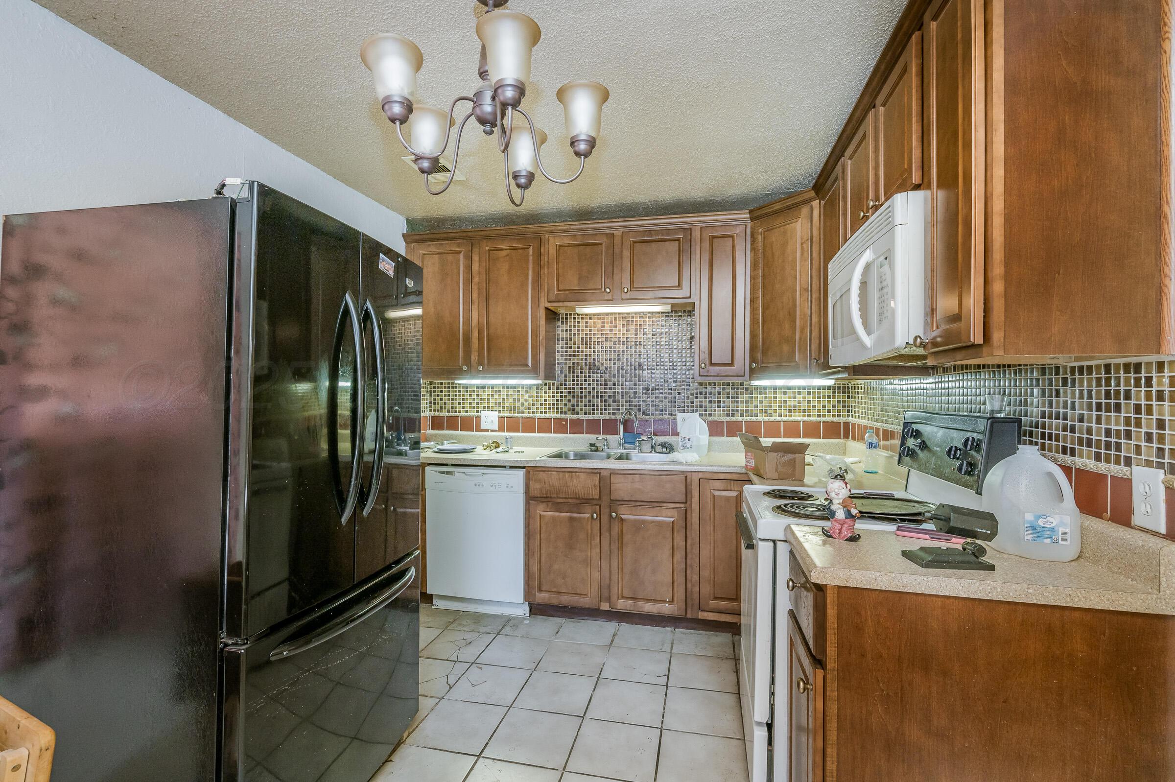 4317 South Polk Street Amarillo, TX 79110 - Photo 7 of 13 a kitchen with stainless steel appliances granite countertop a refrigerator a stove and a sink