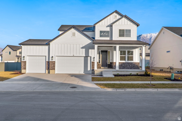 21 South Crimson Way, Unit 310 Mapleton, UT 84664 - Photo 1 of 1 View of front of house with board and batten siding, covered porch, concrete driveway, a shingled roof, and stone siding