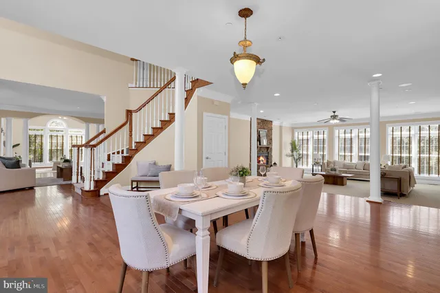 a living room with furniture a large window and wooden floor