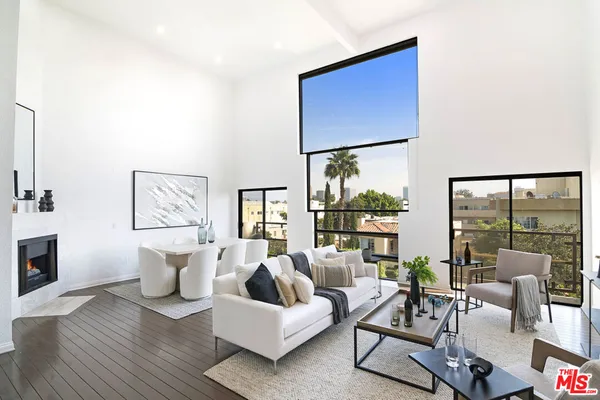 a living room with furniture large window and a fireplace