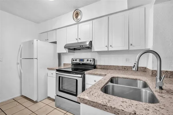 a kitchen with stainless steel appliances a refrigerator and a stove top oven