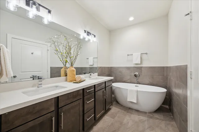 a spacious bathroom with a double vanity sink mirror and bathtub