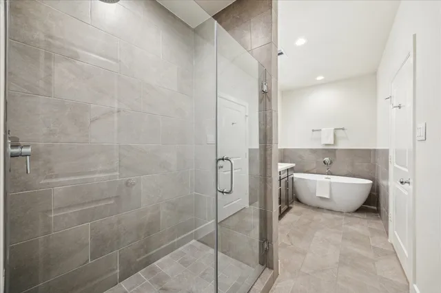 a bathroom with a tub sink and mirror