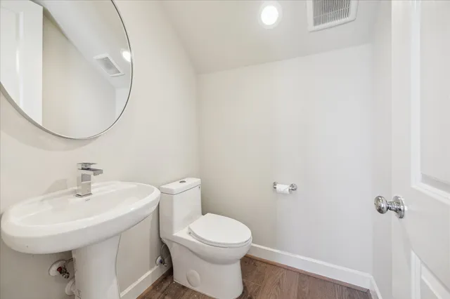 a bathroom with a toilet a sink and mirror
