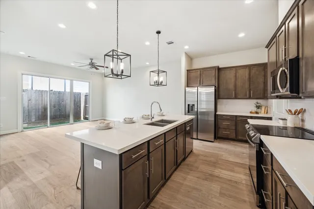 a kitchen with stainless steel appliances granite countertop a sink stove and refrigerator