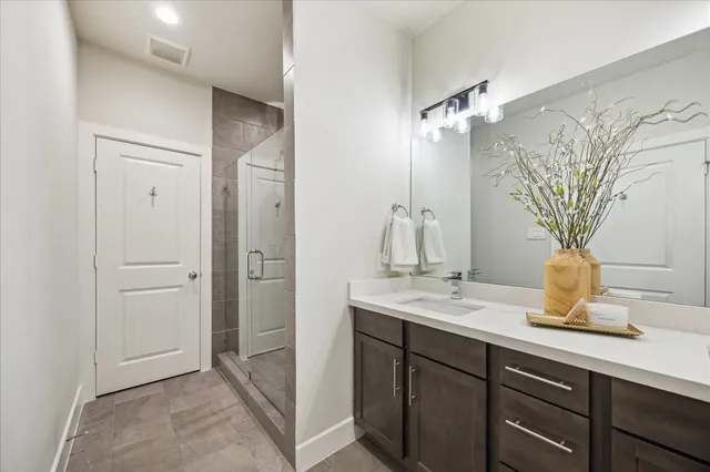 a bathroom with a granite countertop sink a mirror and a shower