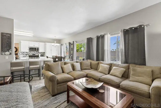 a living room with furniture kitchen view and a refrigerator