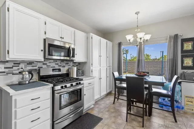 a kitchen with stainless steel appliances a white table and chairs