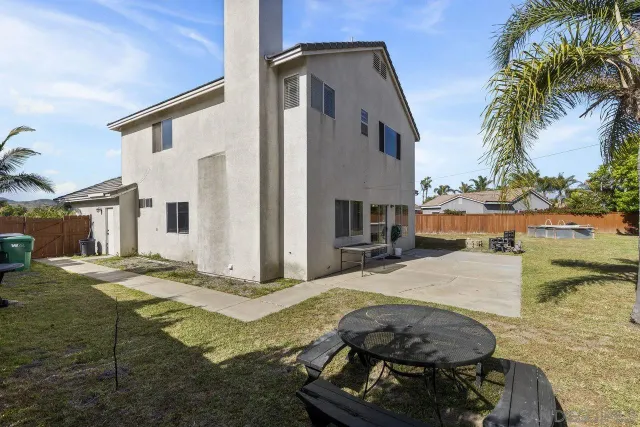 a view of a backyard with furniture and floor to ceiling window