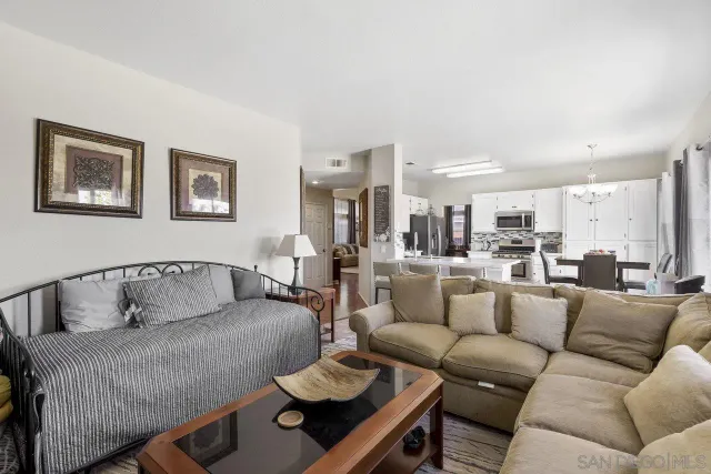 a living room with furniture and a view of kitchen