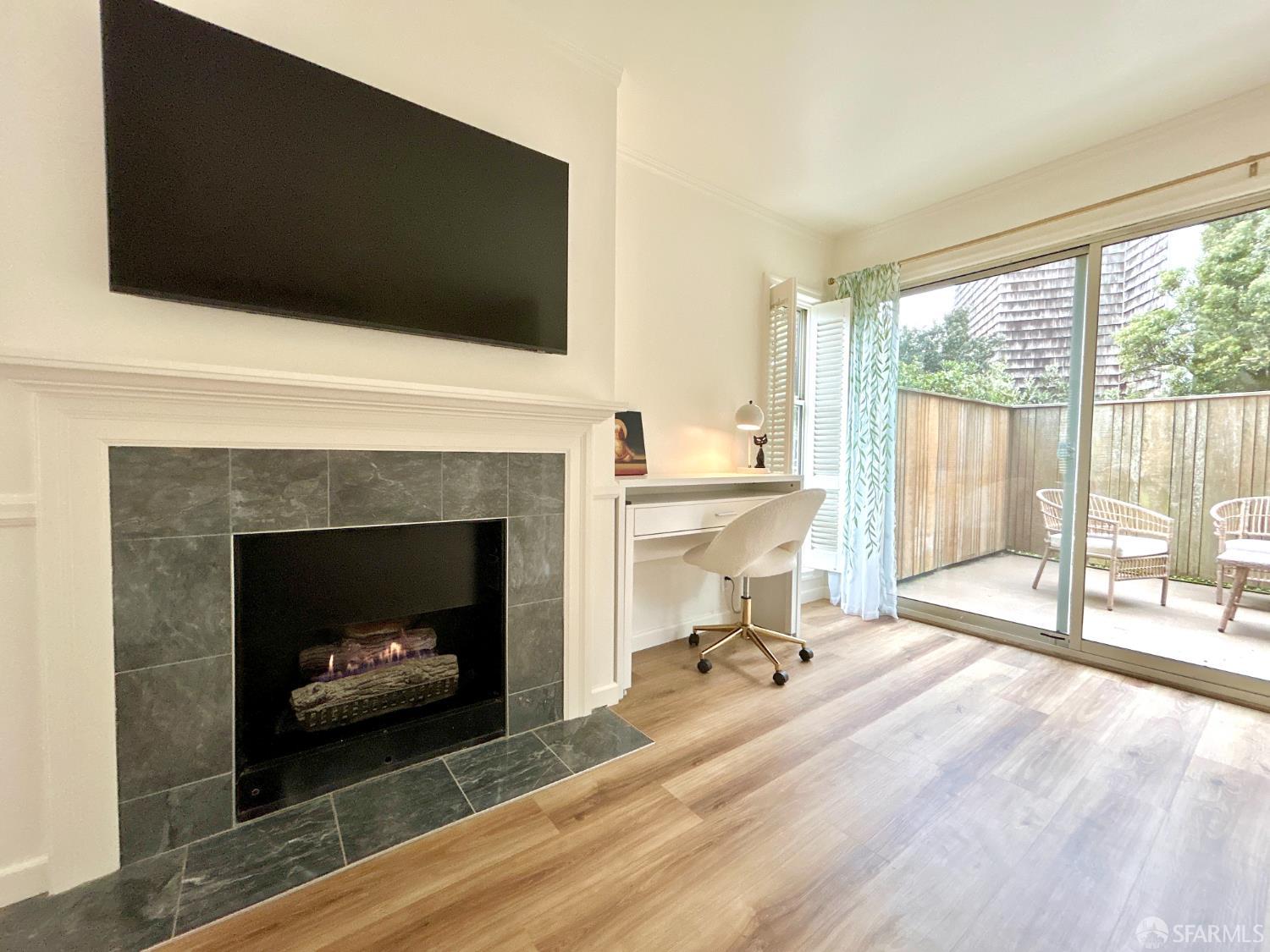 175 Red Rock Way, Unit 101K San Francisco, CA 94131 - Photo 8 of 25 a living room with a fireplace and a flat screen tv