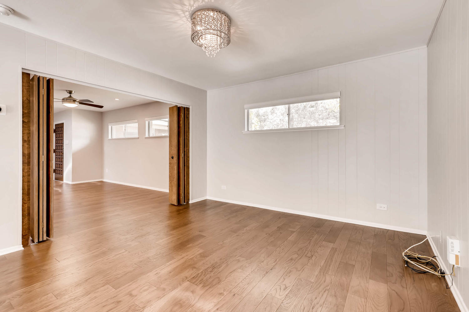 446 Pike Road San Antonio, TX 78209 - Photo 5 of 28 Natural hardwood flooring guides you through this ample living space, featuring an elegant chandelier and sun-filled windows.