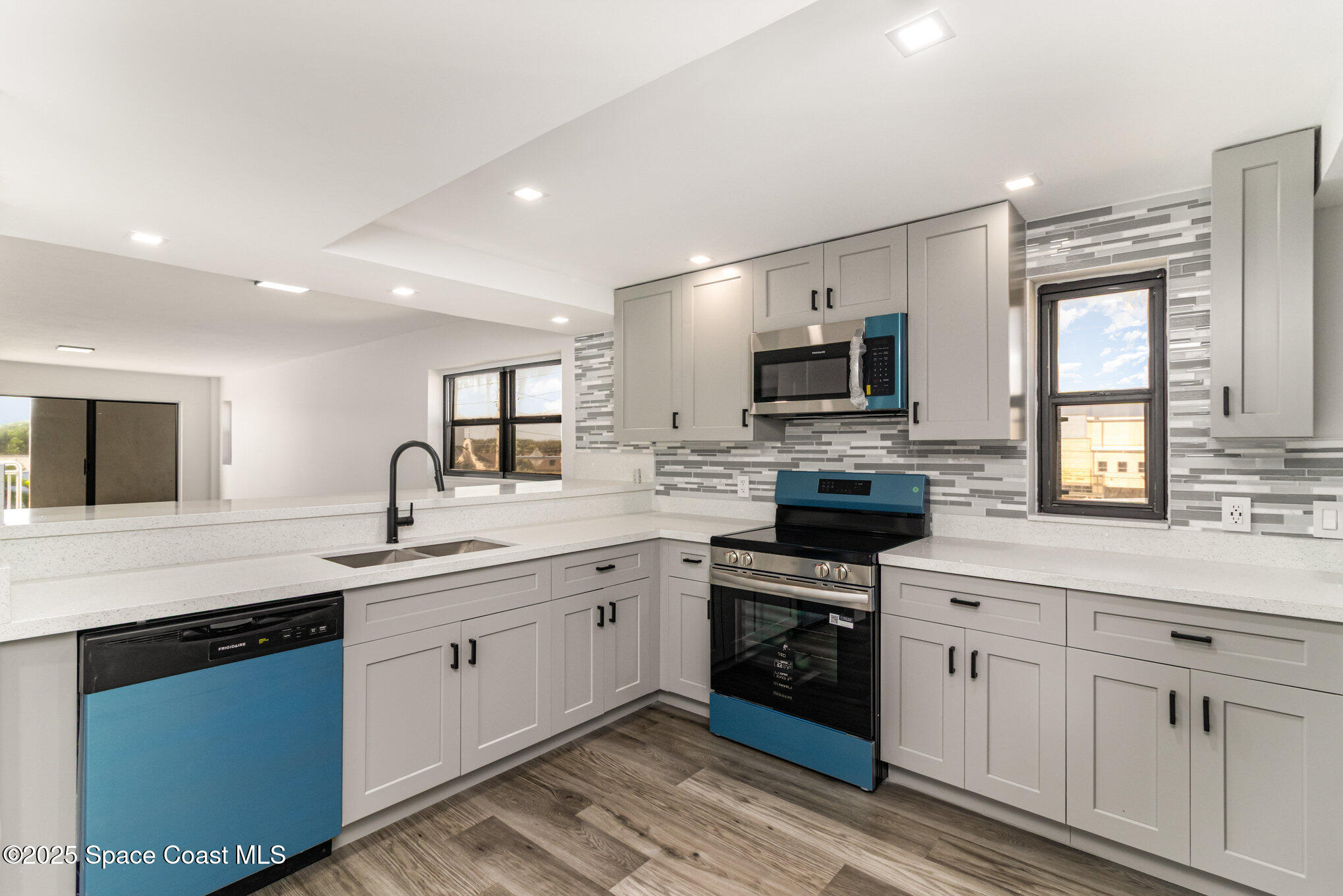 85 South Atlantic Avenue, Unit 306 Cocoa Beach, FL 32931 - Photo 11 of 41 a kitchen with a sink stove and microwave