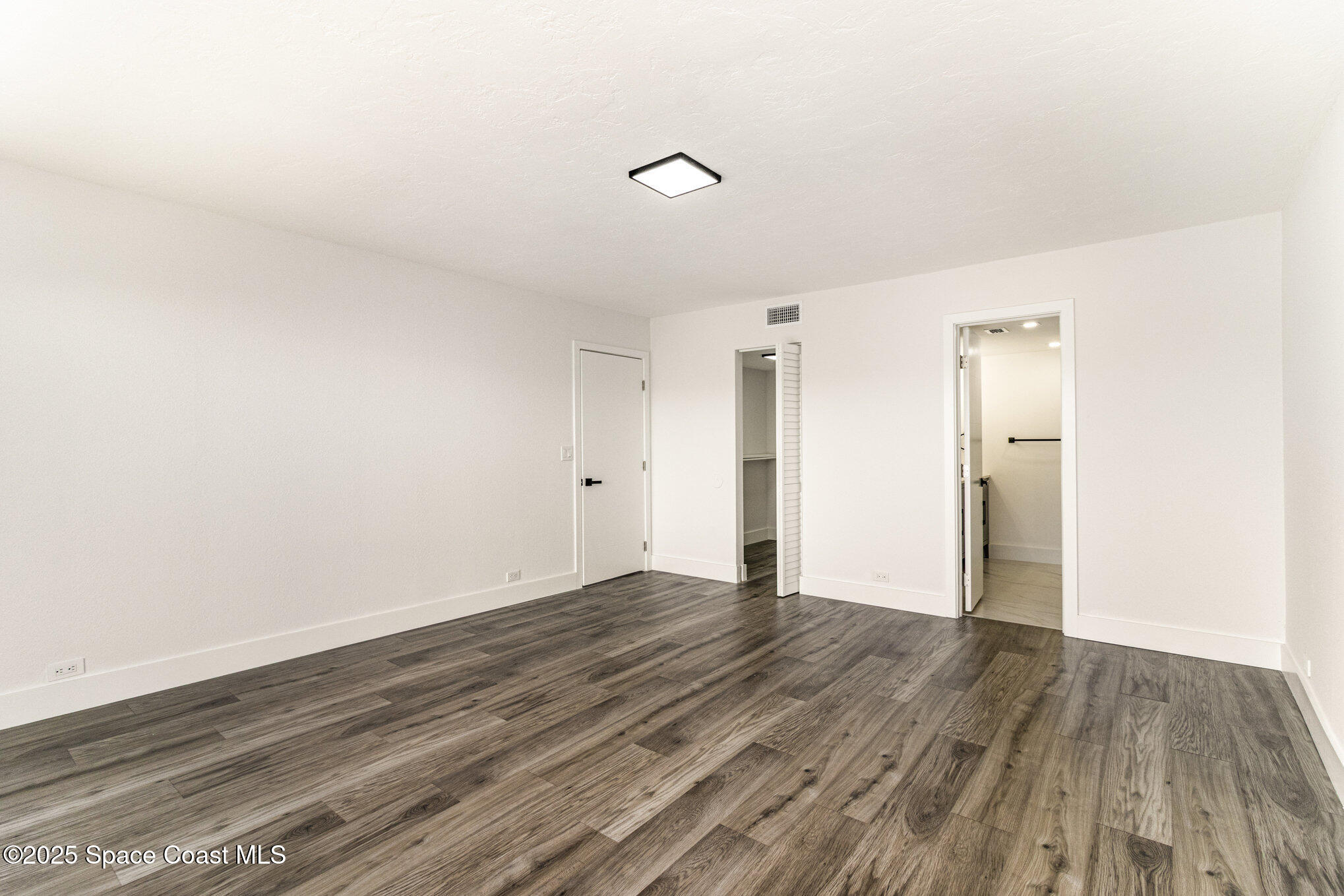 85 South Atlantic Avenue, Unit 306 Cocoa Beach, FL 32931 - Photo 15 of 41 a view of an empty room with wooden floor and a window