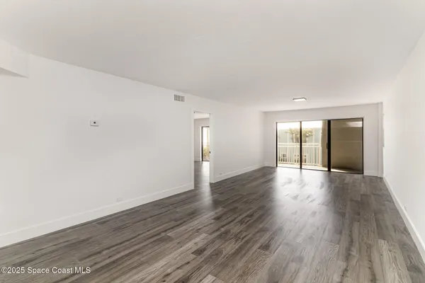 a view of an empty room and wooden floor