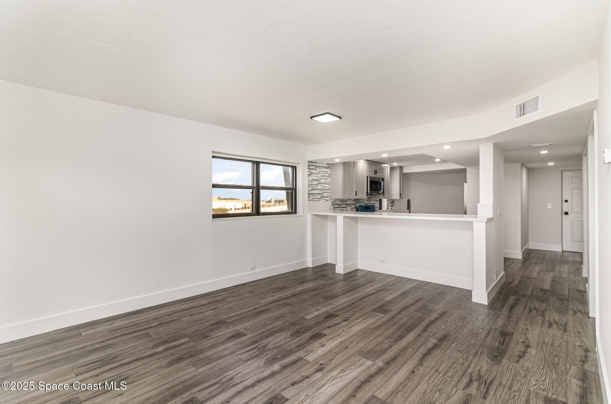 85 South Atlantic Avenue, Unit 306 Cocoa Beach, FL 32931 - Photo 9 of 41 a view of wooden floor and windows in a room