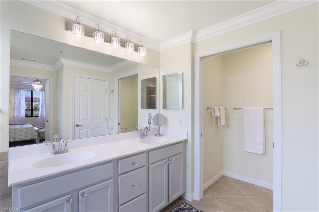 9533 Avellino Way, Unit 2916 Naples, FL 34113 - Photo 15 of 23 a bathroom with a double vanity sink and mirror