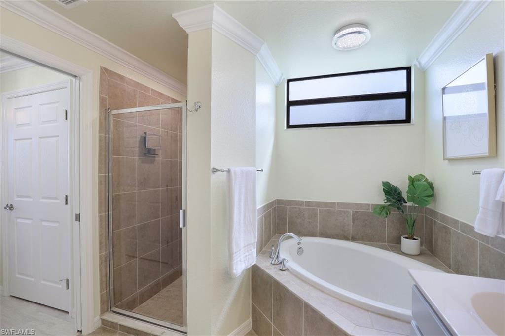 9533 Avellino Way, Unit 2916 Naples, FL 34113 - Photo 16 of 23 a bathroom with a tub shower sink and mirror