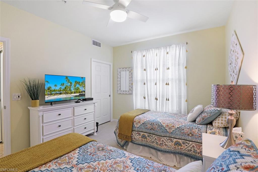 9533 Avellino Way, Unit 2916 Naples, FL 34113 - Photo 19 of 23 a bedroom with a bed and a television