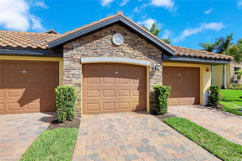 9533 Avellino Way, Unit 2916 Naples, FL 34113 - Photo 2 of 23 a front view of a house with a yard and garage