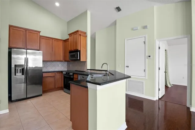 a kitchen with stainless steel appliances granite countertop a stove a refrigerator and a sink