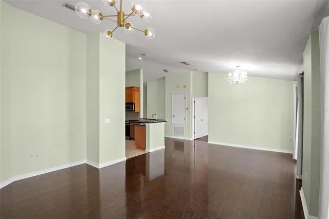 an empty room with wooden floor and a ceiling fan