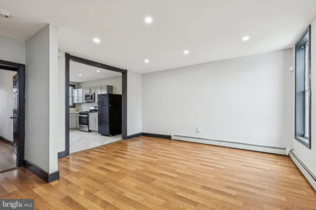 a view of a kitchen with refrigerator and wooden floor