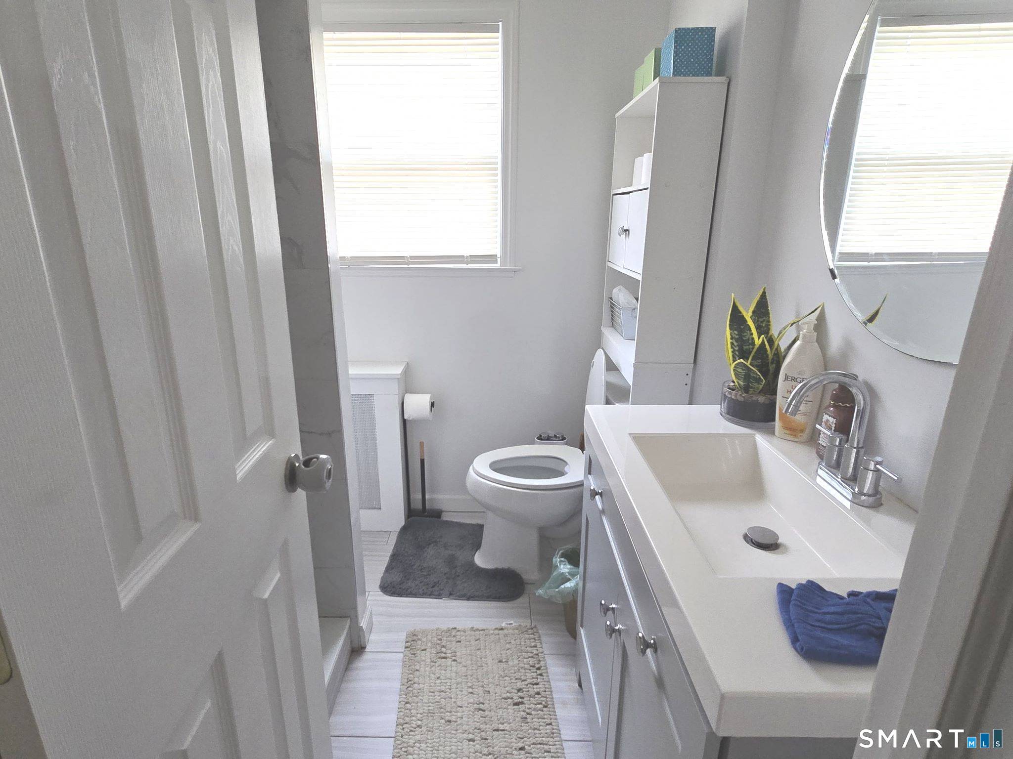 73 Rippowam Road Stamford, CT 06902 - Photo 16 of 19 a bath room with a sink a toilet and a mirror