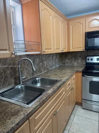 a kitchen with granite countertop a sink and a stove top oven