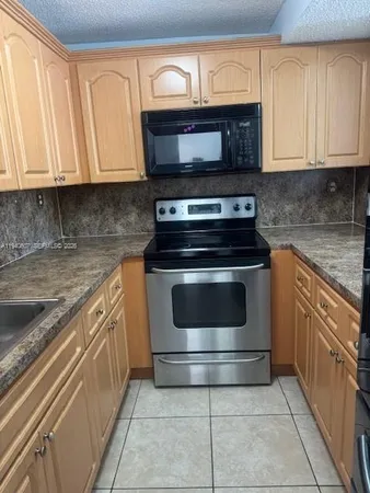 a kitchen with stainless steel appliances granite countertop a stove microwave and oven