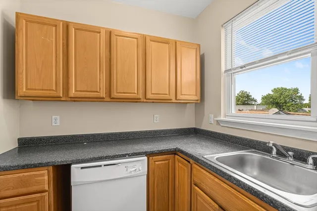 a kitchen with stainless steel appliances granite countertop white cabinets a sink and dishwasher