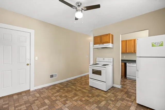 a kitchen with granite countertop a stove a sink and a refrigerator