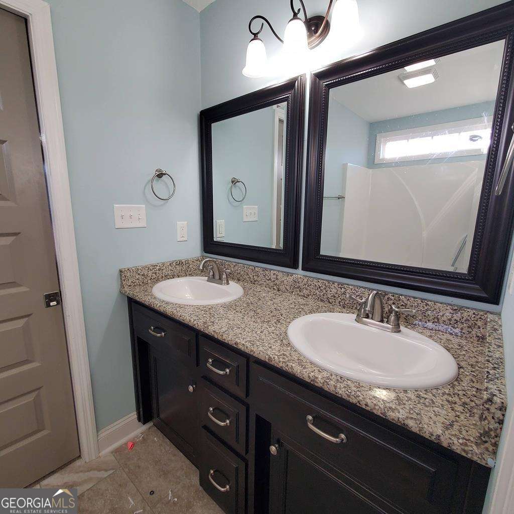 5255 Carlton Ridge Circle Hahira, GA 31632 - Photo 17 of 21 a bathroom with a granite countertop sink a mirror and a vanity
