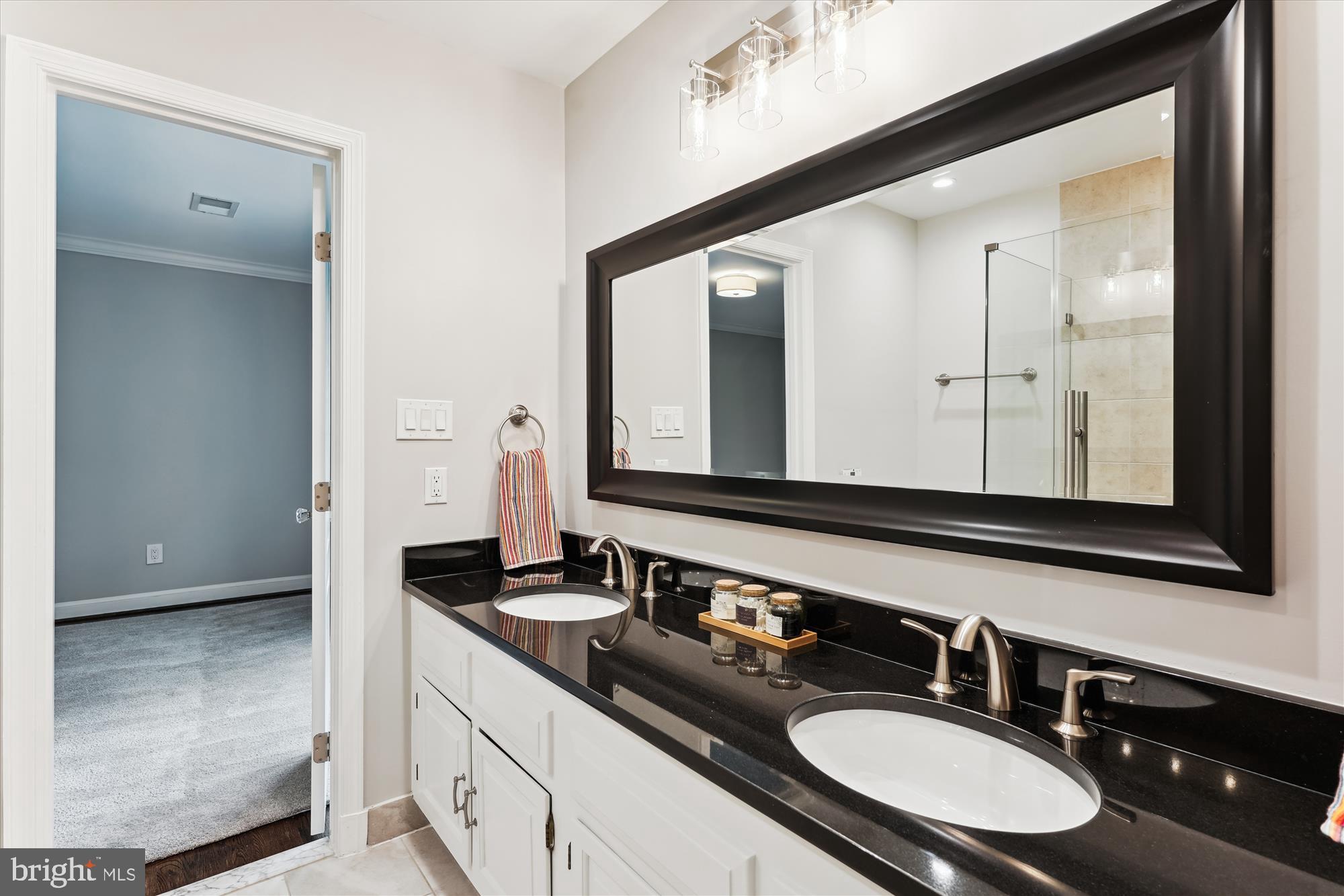 9801 Hall Road Potomac, MD 20854 - Photo 44 of 79 a bathroom with double vanity sinks and a mirror